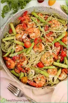 pasta with shrimp, tomatoes and green beans in a skillet on a white table