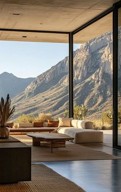 a living room filled with lots of furniture and mountains in the backgroung