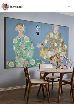 a dining room table with four chairs and a large painting on the wall