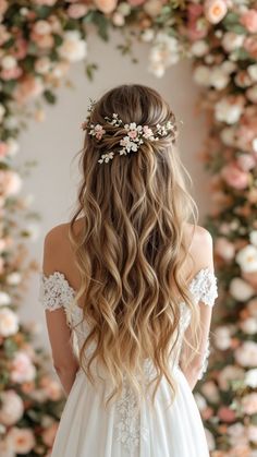 the back of a woman's head with long hair and flowers in her hair