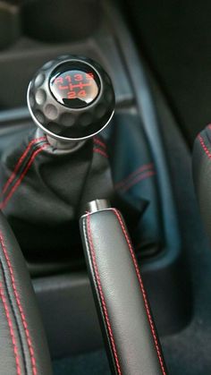 the interior of a car with red stitching