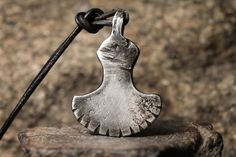 a metal object sitting on top of a piece of wood next to a black cord
