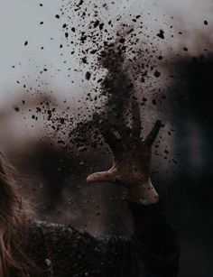 a woman holding her hand up in the air with dirt all over her face and hands