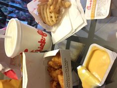 some food is sitting on a table next to a cup of milkshake and fries