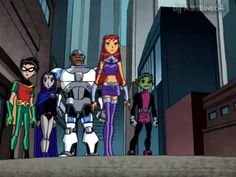 the teen titans standing in front of some tall buildings