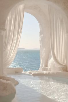 an indoor swimming pool with white curtains and water