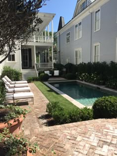 a house with a swimming pool in the middle of it and lawn chairs next to it
