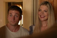 a man standing next to a blonde haired woman