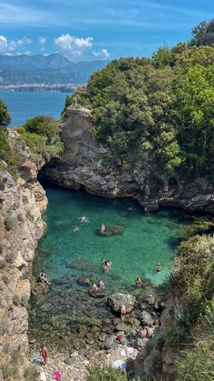 people are swimming in the clear blue water