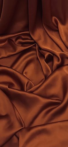 a close up view of an orange colored fabric with very thin folds and wrinkles