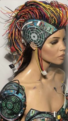 a female mannequin with colorful hair and electronic gadgets on it's head
