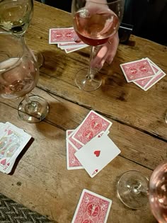 some wine glasses and playing cards on a table