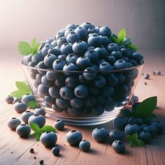 a glass bowl filled with blueberries on top of a wooden table