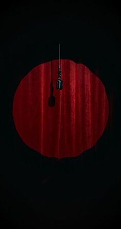 an overhead view of a red round table in the dark, with a black background