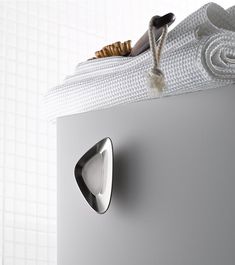 a close up of a door handle on a white cabinet with a towel hanging from it