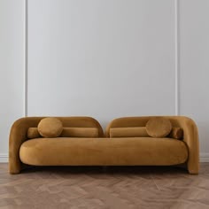 a couch sitting on top of a hard wood floor next to a wall with white walls