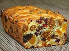 a loaf of fruity bread sitting on top of a wooden table