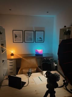 a desk with a camera and some pictures on the wall