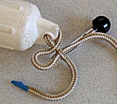 a cord connected to a white bottle on the floor next to a blue toothbrush