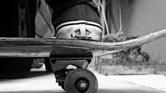 black and white photograph of someone's feet on a skateboard with the wheels down