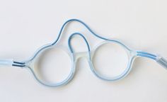 a pair of blue glasses sitting on top of a white table with wires attached to it