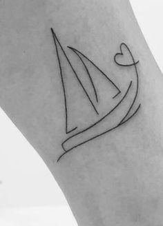 a small sailboat tattoo on the ankle with a heart at the top and an arrow in the middle
