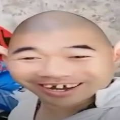 a man with a bald head smiling at the camera