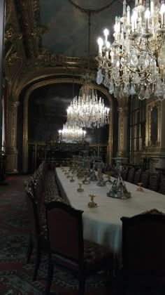 a fancy dining room with chandelier and table