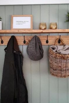 a coat rack with two coats hanging from it's hooks and three baskets on the wall