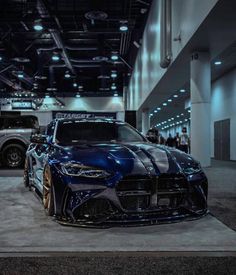 two blue sports cars parked in a showroom