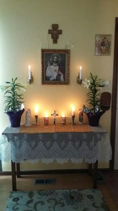 a table with candles and pictures on the wall