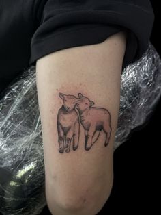 a woman's arm with two sheep tattoo on the left side of her leg