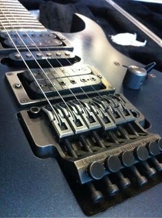 an electric guitar is laying on top of some sort of device that looks like it's made out of metal
