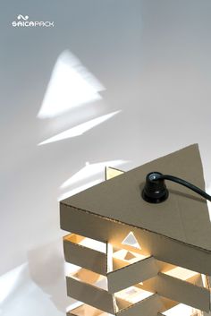 a lamp that is sitting on top of a cardboard box with some light coming from it