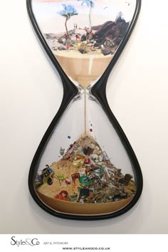 an hourglass is filled with trash and other things on the beach, as well as palm trees
