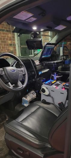 the interior of a vehicle with electronic equipment on the dashboard and in the passenger seat