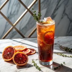 a drink with orange slices and herbs on the table