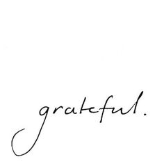 the word grateful written in cursive writing on a white paper with black ink