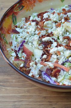 a bowl filled with lots of food on top of a wooden table