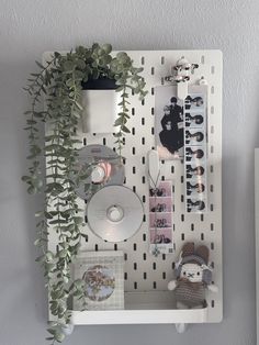 a white shelf with various items on it and a potted plant next to it