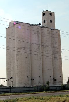 an old grain silo sits next to the highway