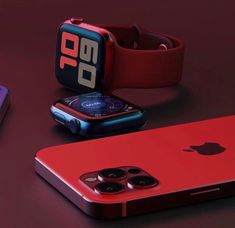 an apple watch and red iphone are next to each other on a dark surface,