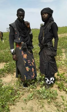 two people standing in a field with grass