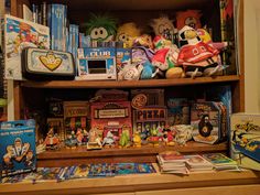 a wooden shelf filled with lots of toys and games on top of it's shelves
