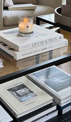 a glass table topped with books and a candle