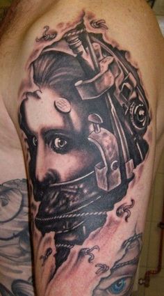 a man with a tattoo on his arm and shoulder is wearing a helmet that has an image of a woman's face in the middle