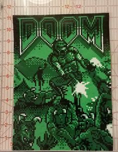 a piece of art made out of legos on top of a cutting board next to a ruler