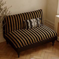 a black and brown striped couch sitting next to a window