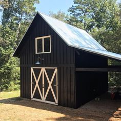 a large black barn with a metal roof