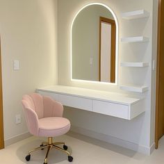 a pink chair sitting in front of a white desk with a mirror on top of it